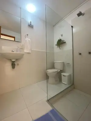 a white bathroom with a toilet and a sink at Casa Trinidad Getsemaní Hotel in Cartagena de Indias
