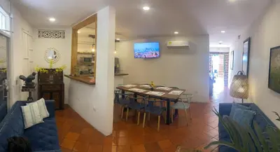 a dining room and living room with a table and chairs at Casa Trinidad Getsemaní Hotel in Cartagena de Indias