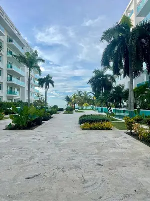 a walkway with palm trees in front of a building at Apartamento en Cartagena cerca al hotel las Américas in Cartagena de Indias