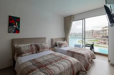 a hotel room with two beds and a large window at BAIA KRISTAL CARTAGENA Mi descanso ideal in Cartagena de Indias