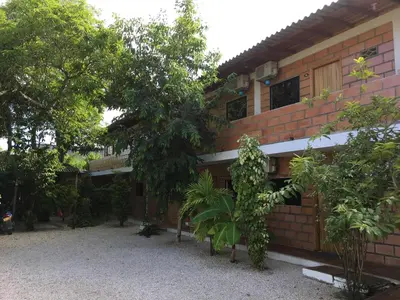 a brick building with trees in front of it at Hotel Pizzeria Opera Tolú in Tolú