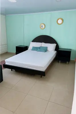 a bedroom with a large bed with white sheets at Tu Casa con Vista al Mar , Laguito-Bocagrande in Cartagena de Indias