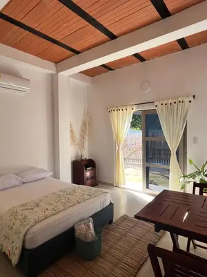 a bedroom with a bed and a table and a window at Isla Rosa Coveñas - Alojamiento in Coveñitas
