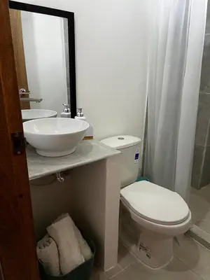 a bathroom with a sink and a toilet and a mirror at Isla Rosa Coveñas - Alojamiento in Coveñitas
