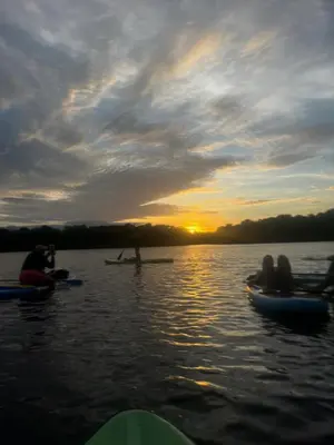 a group of people on kayaks on a lake at sunset at Isla Rosa Coveñas - Alojamiento in Coveñitas