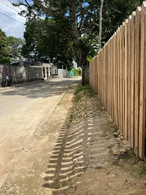 a fence on the side of a road next to a tree at Isla Rosa Coveñas - Alojamiento in Coveñitas