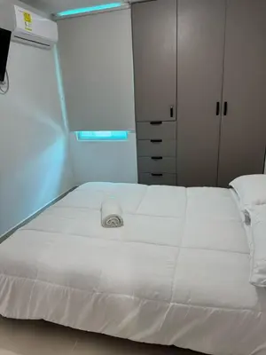a large white bed in a room with a window at Apartamento moderno en zona norte exclusiva in Barranquilla