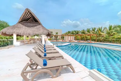 a row of chaise lounge chairs next to a swimming pool at Casa Areia Frente Al Mar, Playa Privada in Playa Blanca