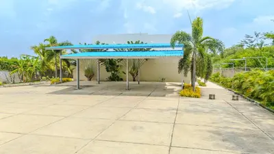 a pavilion with a blue roof and palm trees at Casa Areia Frente Al Mar, Playa Privada in Playa Blanca