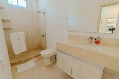 a bathroom with a toilet and a sink and a mirror at Casa Areia Frente Al Mar, Playa Privada in Playa Blanca