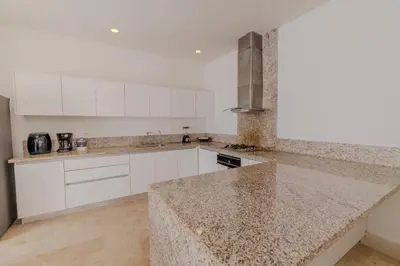 a kitchen with white cabinets and a granite counter top at Casa Areia Frente Al Mar, Playa Privada in Playa Blanca
