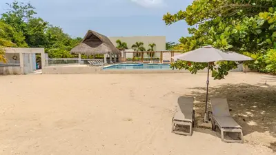 a couple of chairs and an umbrella on the beach at Casa Areia Frente Al Mar, Playa Privada in Playa Blanca