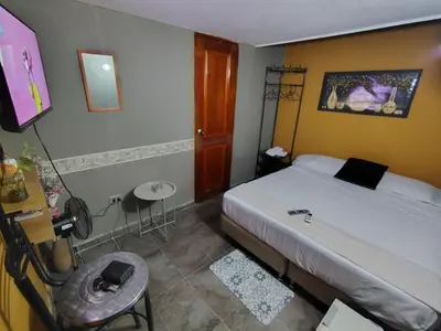 a bedroom with a bed and a table and a chair at Tiny Room con Ventilador in Cartagena de Indias