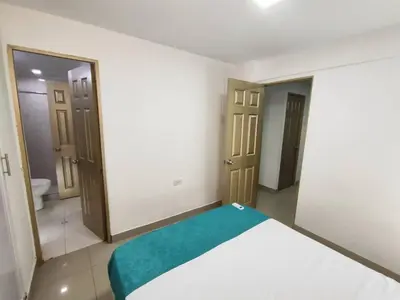 a bedroom with a bed with a green blanket at Cozy 2nd Floor Apartment in Heart of Cartagena in Cartagena de Indias