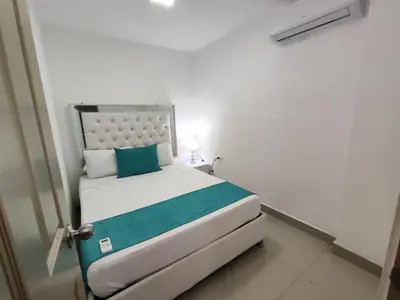 a bedroom with a bed in a white room at Cozy 2nd Floor Apartment in Heart of Cartagena in Cartagena de Indias