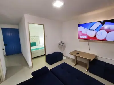 a living room with a blue couch and a mirror at Cozy 2nd Floor Apartment in Heart of Cartagena in Cartagena de Indias