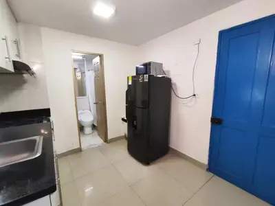 a kitchen with a refrigerator and a blue door at Cozy 2nd Floor Apartment in Heart of Cartagena in Cartagena de Indias