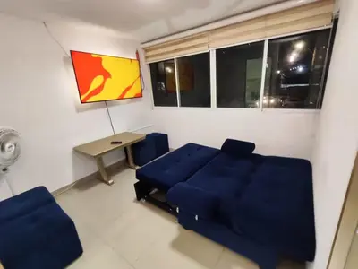 a living room with a blue couch and a table at Cozy 2nd Floor Apartment in Heart of Cartagena in Cartagena de Indias