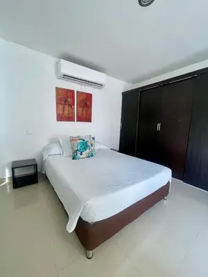 a bedroom with a large bed and a black cabinet at Apartamento 201 frente a hotel Las américas in Cartagena de Indias