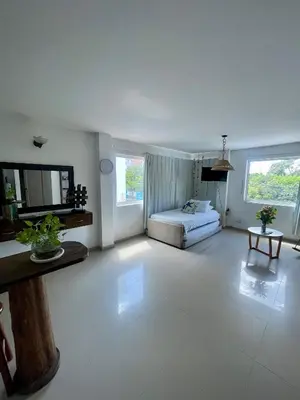a large white room with a bed and a table at Apartamento 201 frente a hotel Las américas in Cartagena de Indias