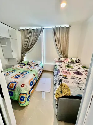 a bedroom with two beds and a chair in it at Moderno apartamento con vista al mar en Cartagena in Cartagena de Indias