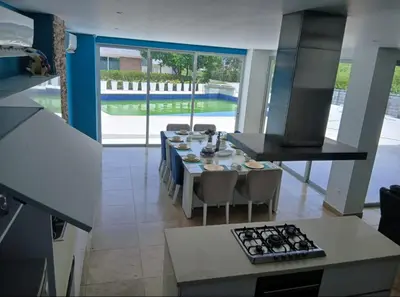 a kitchen with a table with chairs and a stove at Resort frente al mar in Juan de Acosta
