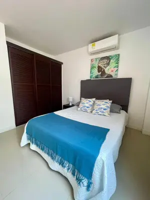 a bedroom with a large bed with a blue blanket at Cielo Mar 102 frente a Hotel Las Américas in Cartagena de Indias