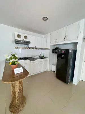 a kitchen with white cabinets and a black refrigerator at Cielo Mar 102 frente a Hotel Las Américas in Cartagena de Indias