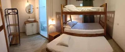 a room with two bunk beds and a bathroom at Mar Barú Beach House in Playa Blanca