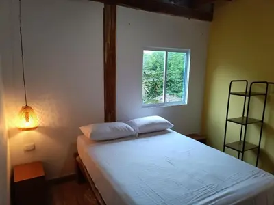a bedroom with a white bed with a window at Mar Barú Beach House in Playa Blanca