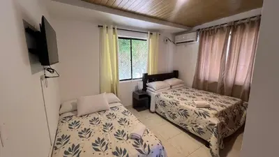 a bedroom with two beds and a tv and a window at Apartamento 6 pax in Estación El Salto