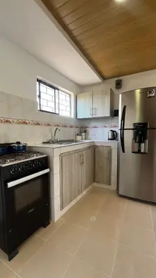 a kitchen with a stove and a refrigerator at Apartamento 6 pax in Estación El Salto