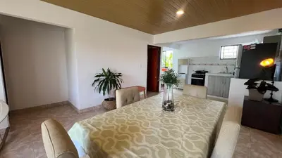 a dining room with a table and chairs and a kitchen at Apartamento 6 pax in Estación El Salto