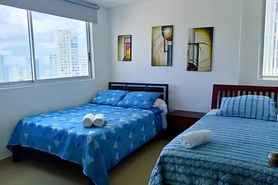 a bedroom with two beds and two windows at Increíble vista al mar en el corazón de Bocagrande in Cartagena de Indias