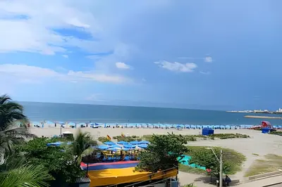 a beach with a bunch of umbrellas and people on the beach at Increíble vista al mar en el corazón de Bocagrande in Cartagena de Indias