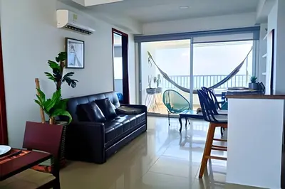 a living room with a black leather couch and a table at Increíble vista al mar en el corazón de Bocagrande in Cartagena de Indias