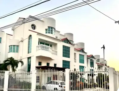 a white building behind a white fence at Casa de lujo en Condominio Privado por Habitaciones in Cartagena de Indias