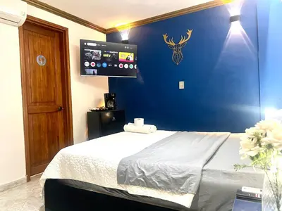 a bedroom with a bed with a blue wall at Casa de lujo en Condominio Privado por Habitaciones in Cartagena de Indias
