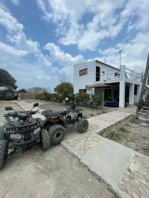 a couple of atvs and two atvs parked in front of a building at Villa del Atardecer Caribeño - JhonLimar in Bocachica