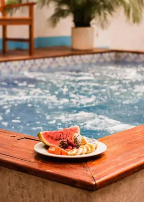 a plate of fruit on a table next to a swimming pool at Hb-m8 House With 8 Bedrooms, Pool And Near The Sea in Cartagena de Indias