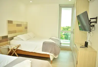 a bedroom with a bed and a flat screen tv at Magico Apartamento Frente al Mar 3 Habitaciones CV41 in Coveñitas