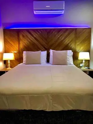 a bedroom with a large white bed with two lamps at Cartagena Vibes House in Cartagena de Indias