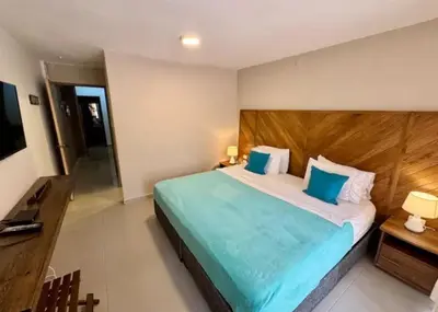 a bedroom with a large bed with a wooden headboard at Cartagena Vibes House in Cartagena de Indias