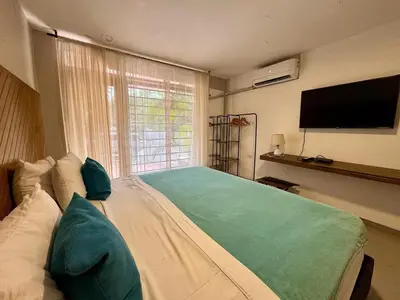 a bedroom with a large bed with a flat screen tv at Cartagena Vibes House in Cartagena de Indias