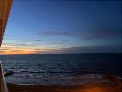 a view of the ocean at sunset from a window at Condominio exclusivo Cartagena Beach in Cartagena de Indias