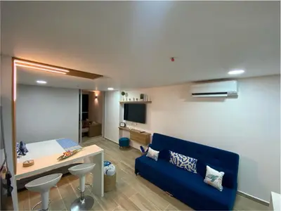 a living room with a blue couch and a table at Condominio exclusivo Cartagena Beach in Cartagena de Indias