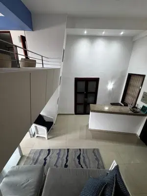 a living room with a couch and a staircase at Luxury 2B Duplex in Old City Cartagena in Cartagena de Indias