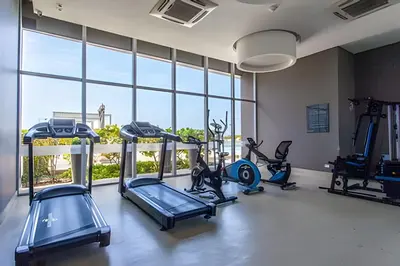 a gym with treadmills and ellipticals in a room with windows at 1004 Morros City - Spectacular 1 Bedroom Condo in Cartagena de Indias