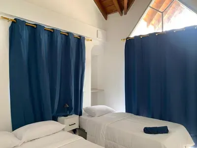 two beds in a room with blue curtains at Hotel Boutique DL in Cartagena de Indias