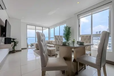 a dining room and living room with a table and chairs at Espectacular Apto 3 Hab Palmetto Beach 1201 in Cartagena de Indias